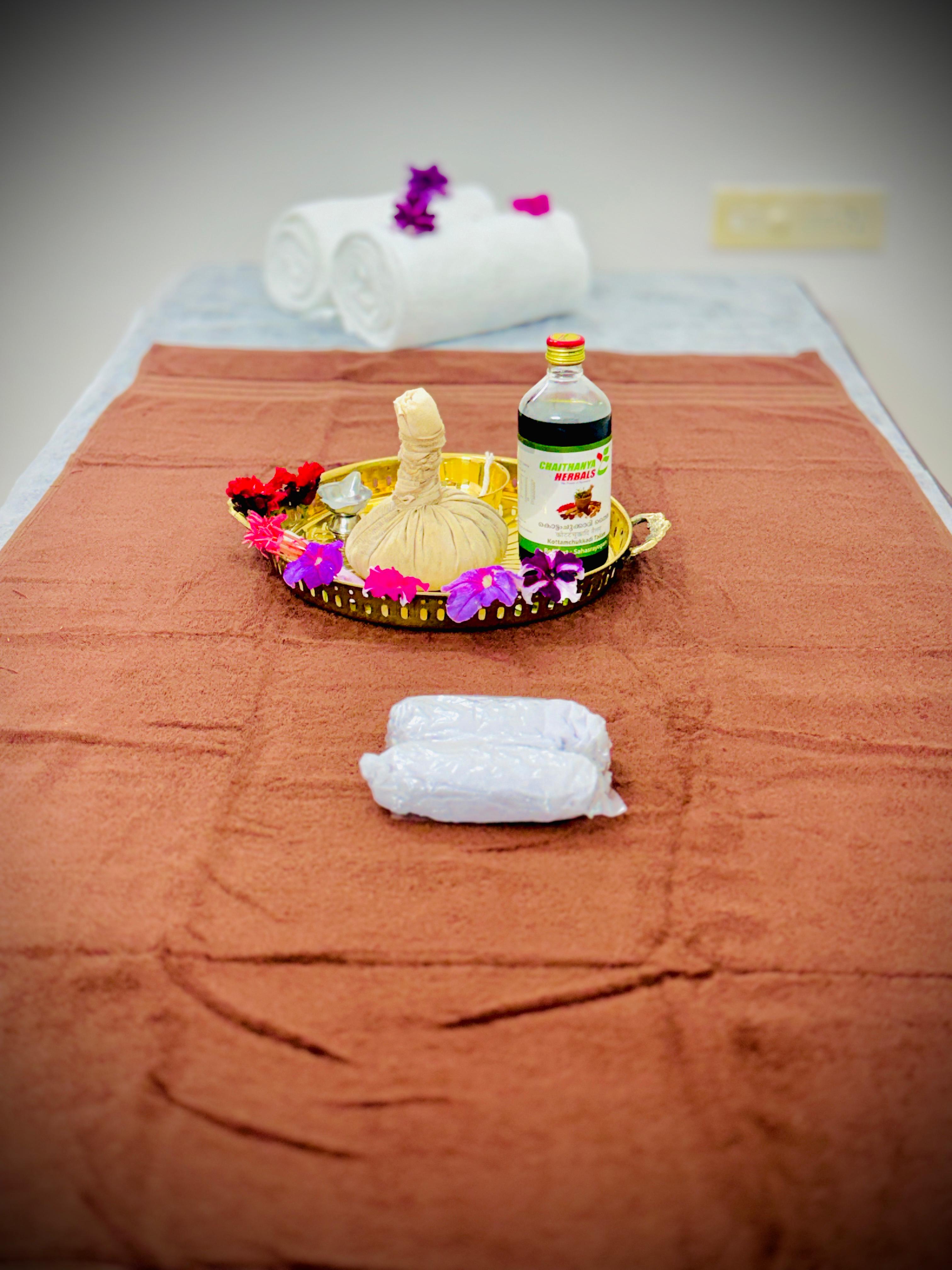 Close-up of hands performing a gentle Ayurvedic Abhyanga massage.