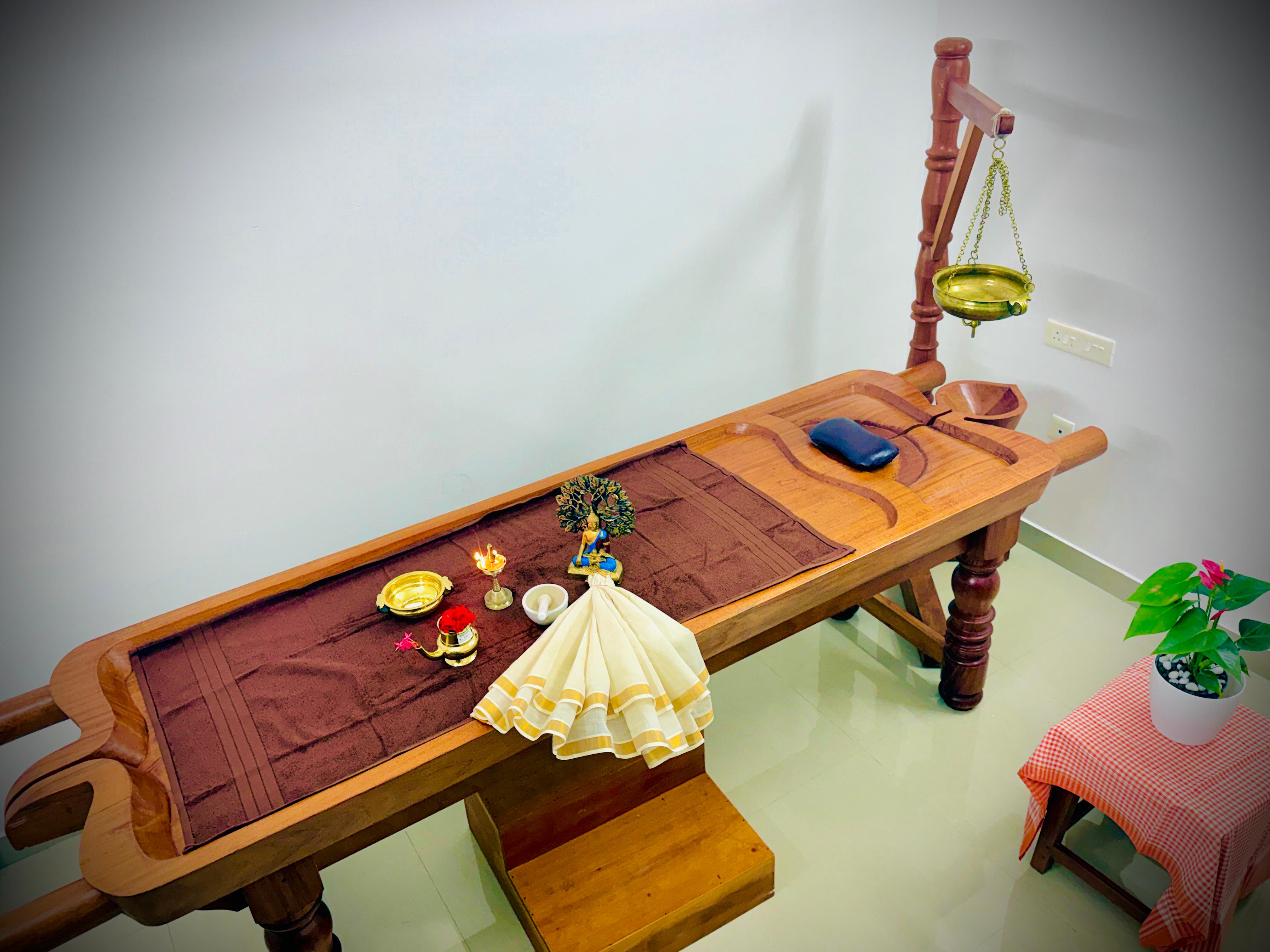 Ayurvedic therapist preparing herbal massage oils for a wellness treatment.