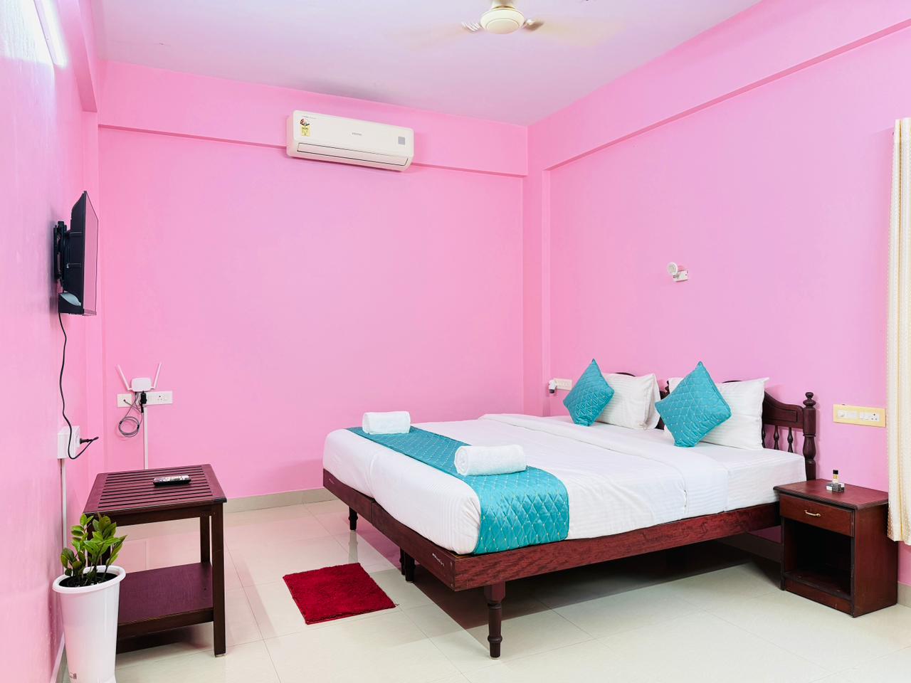 Bright guest room with twin beds, air conditioning, and television