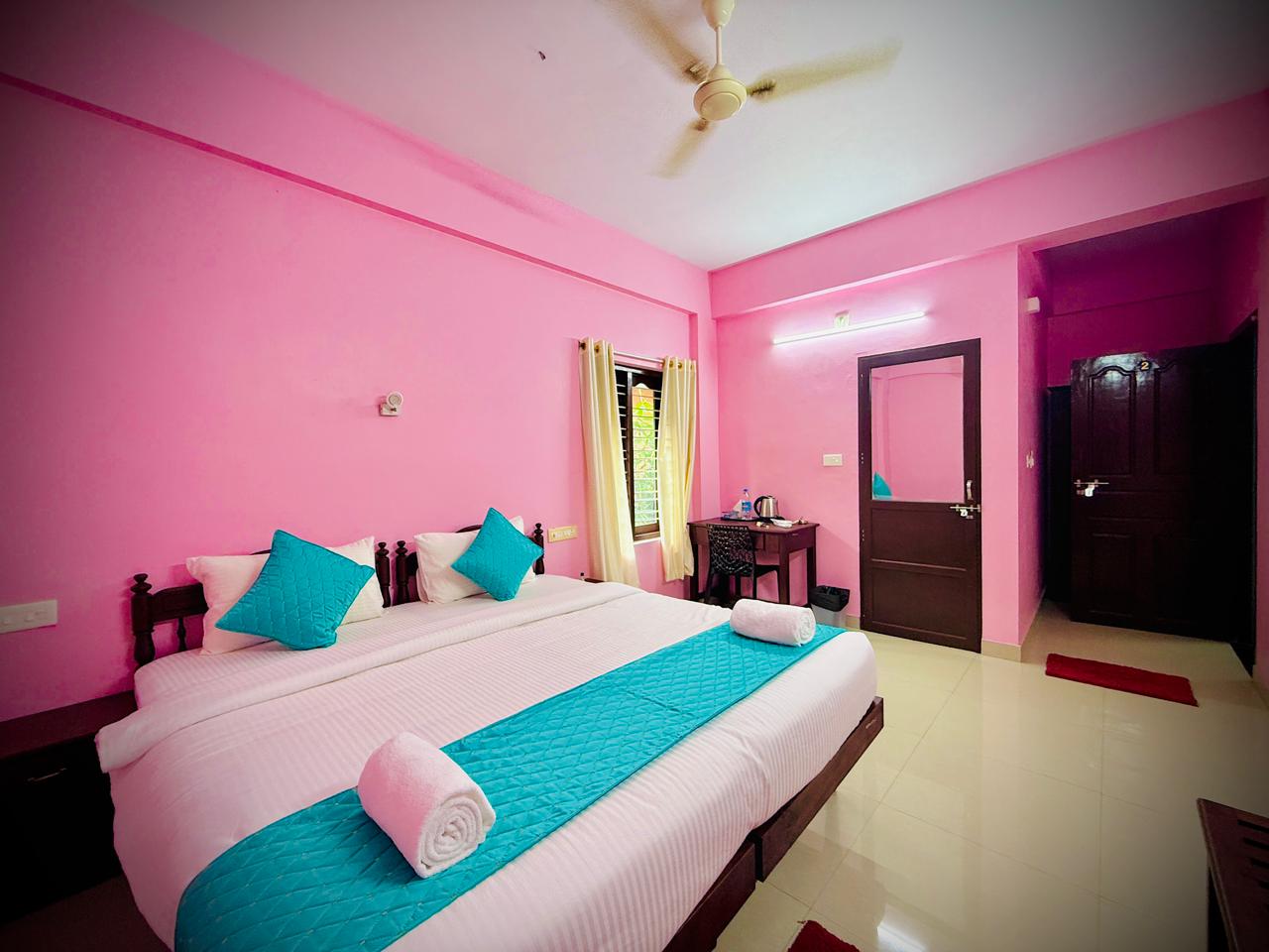 Double guest room with turquoise runner, desk, and warm lighting