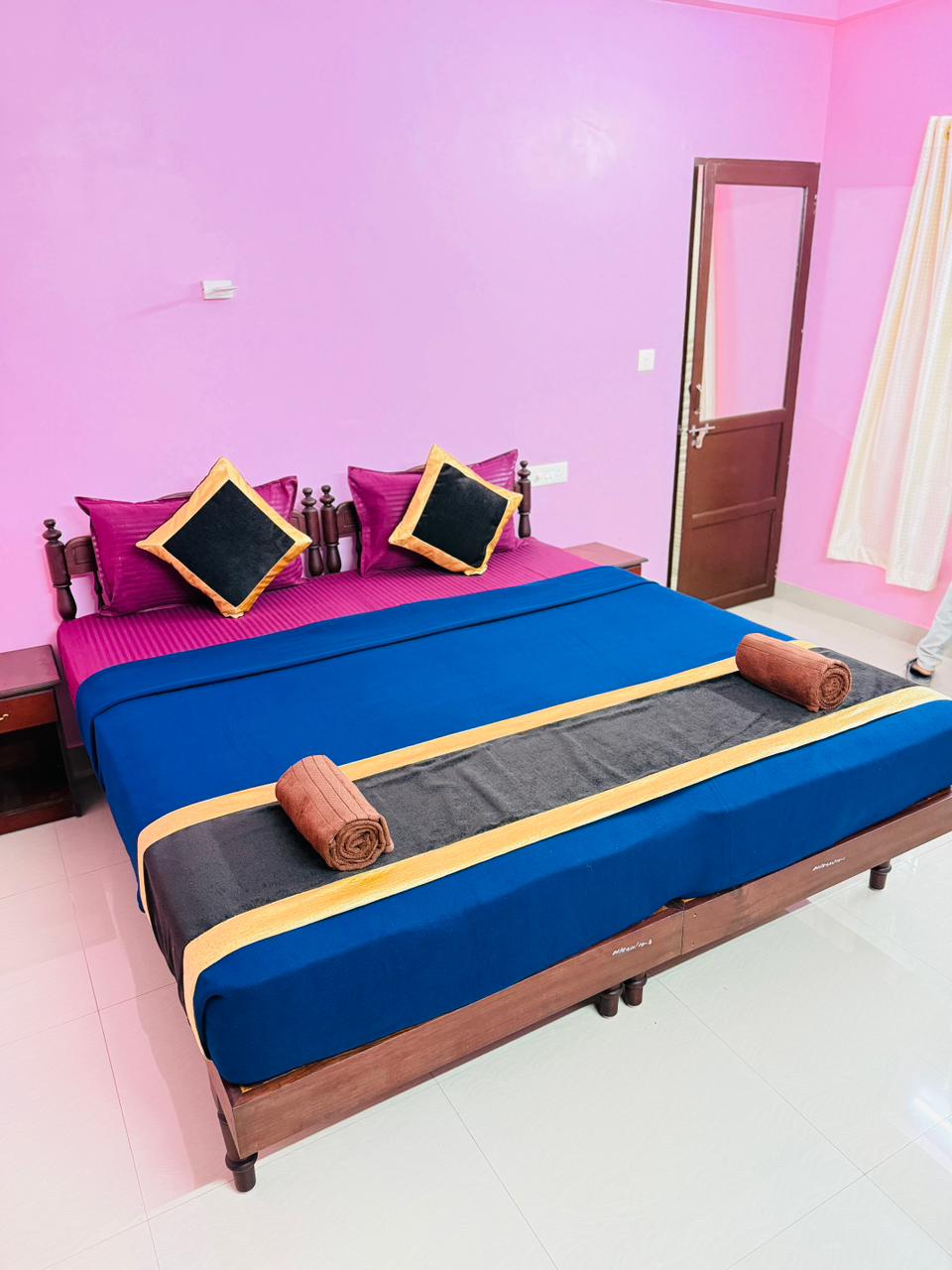 Double bed with blue bedding and compact room layout