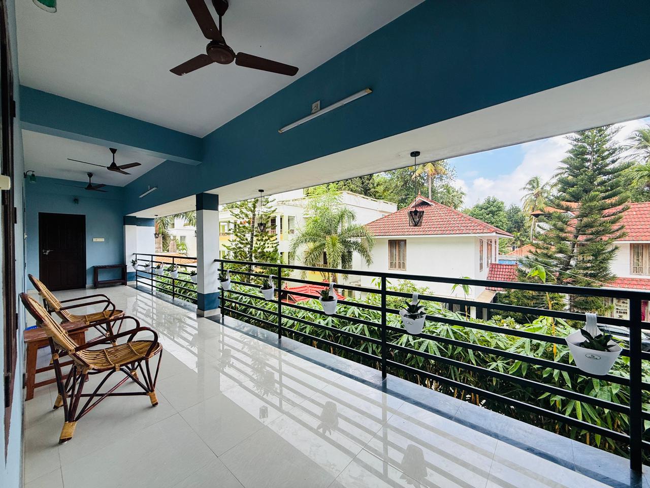Long balcony corridor overlooking trees and tiled roofs
